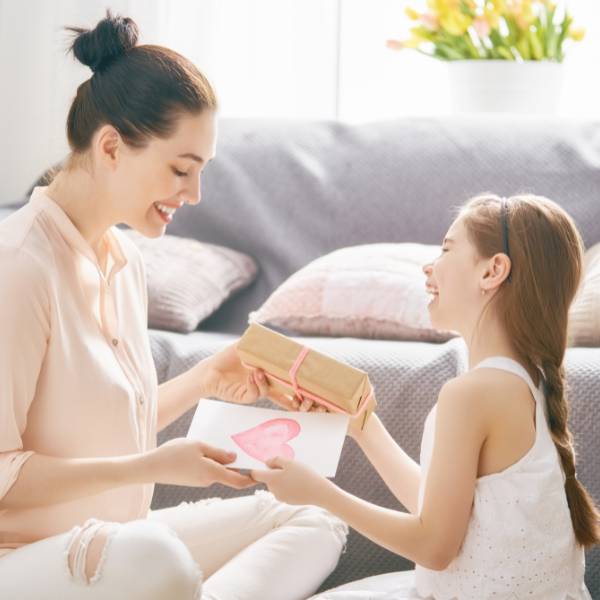 A young girl giving her mother a gift card for house cleaning services